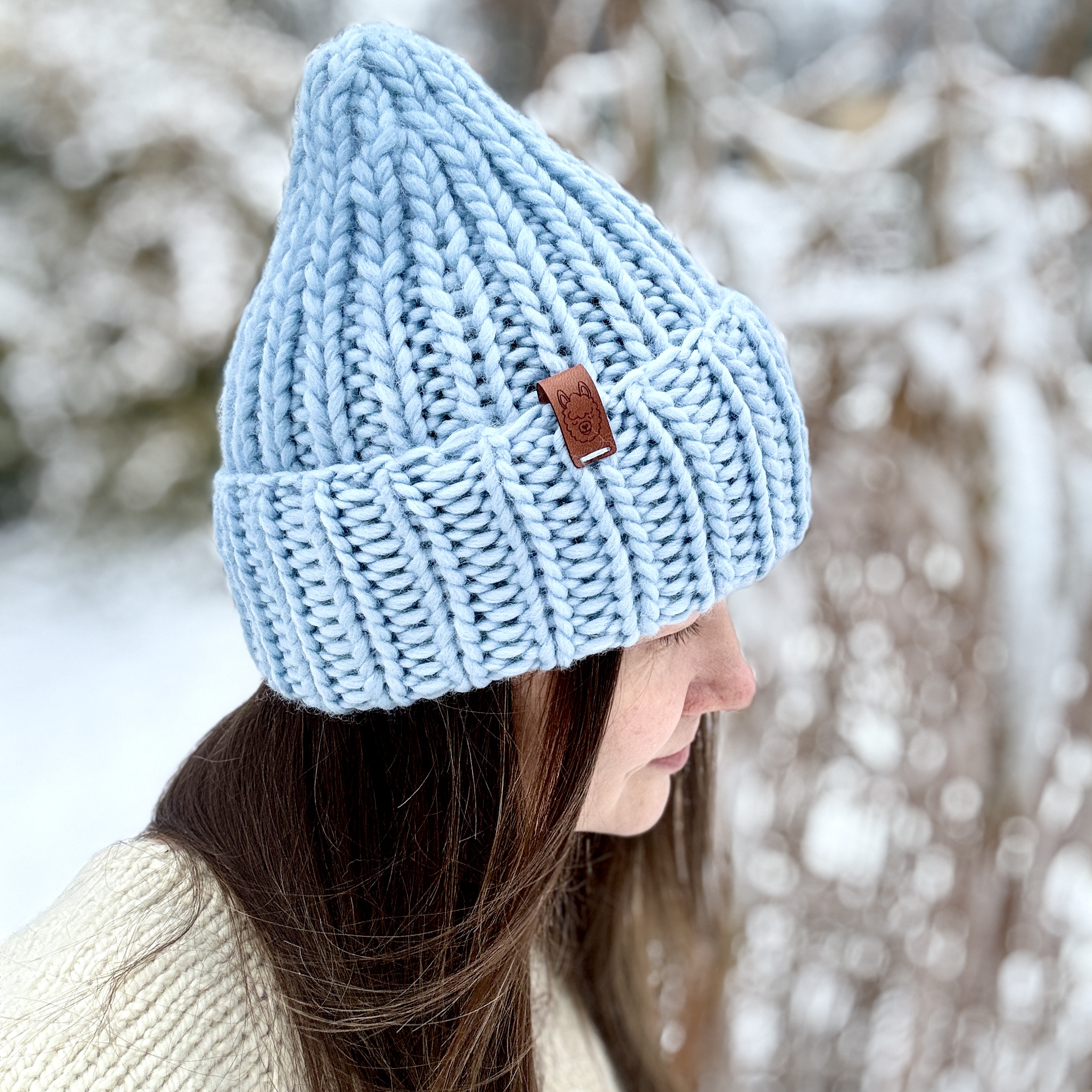 Ciepła, zimowa czapka z wełny na głowie modelki.