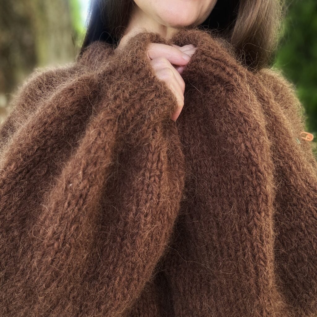 Detal rękawów w swetrze handmade z wełny alpaki w kolorze ciemnej czekolady