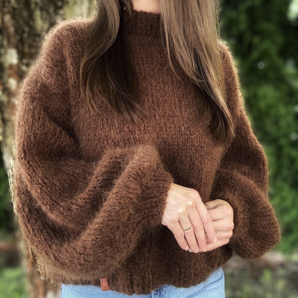 Ręcznie robiony sweter z wełny alpaki i merino w kolorze brazowym, prezenrowany na modelce od przodu